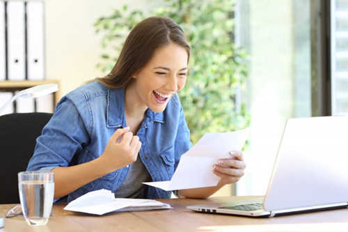 Woman celebrating after looking at her dental insurance benefits