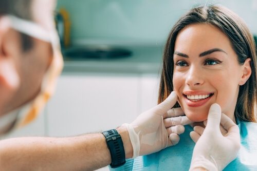 Woman smiling in dental chair after cosmetic dentistry in Pecan Grove