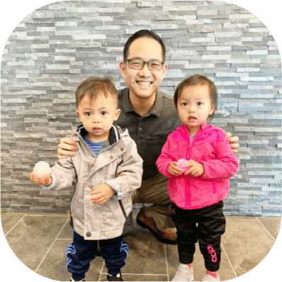Doctor Albert Kim smiling in dental office with two children