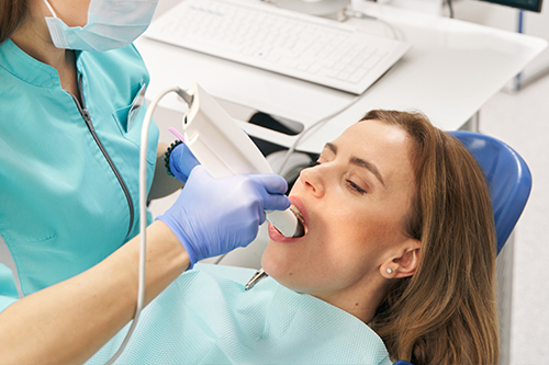 Dentist taking intraoral scans of a patients teeth